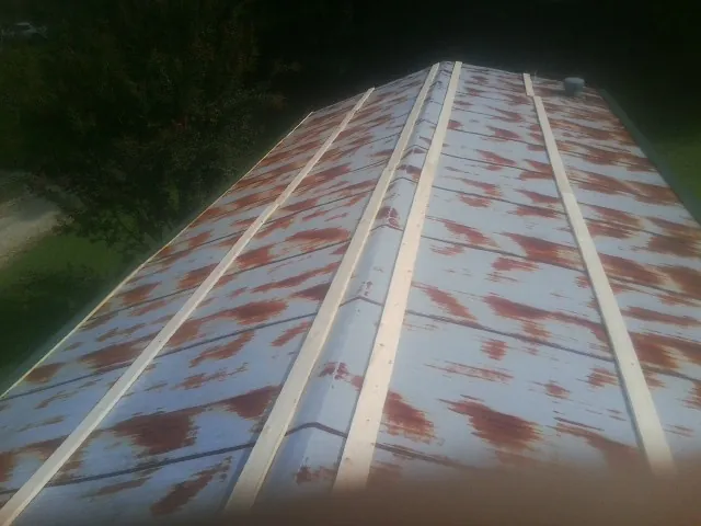 Rusted metal roof panels with new wood purlins before replacement — Storm Damage Roof Repair in Starkville by Roofing Brothers