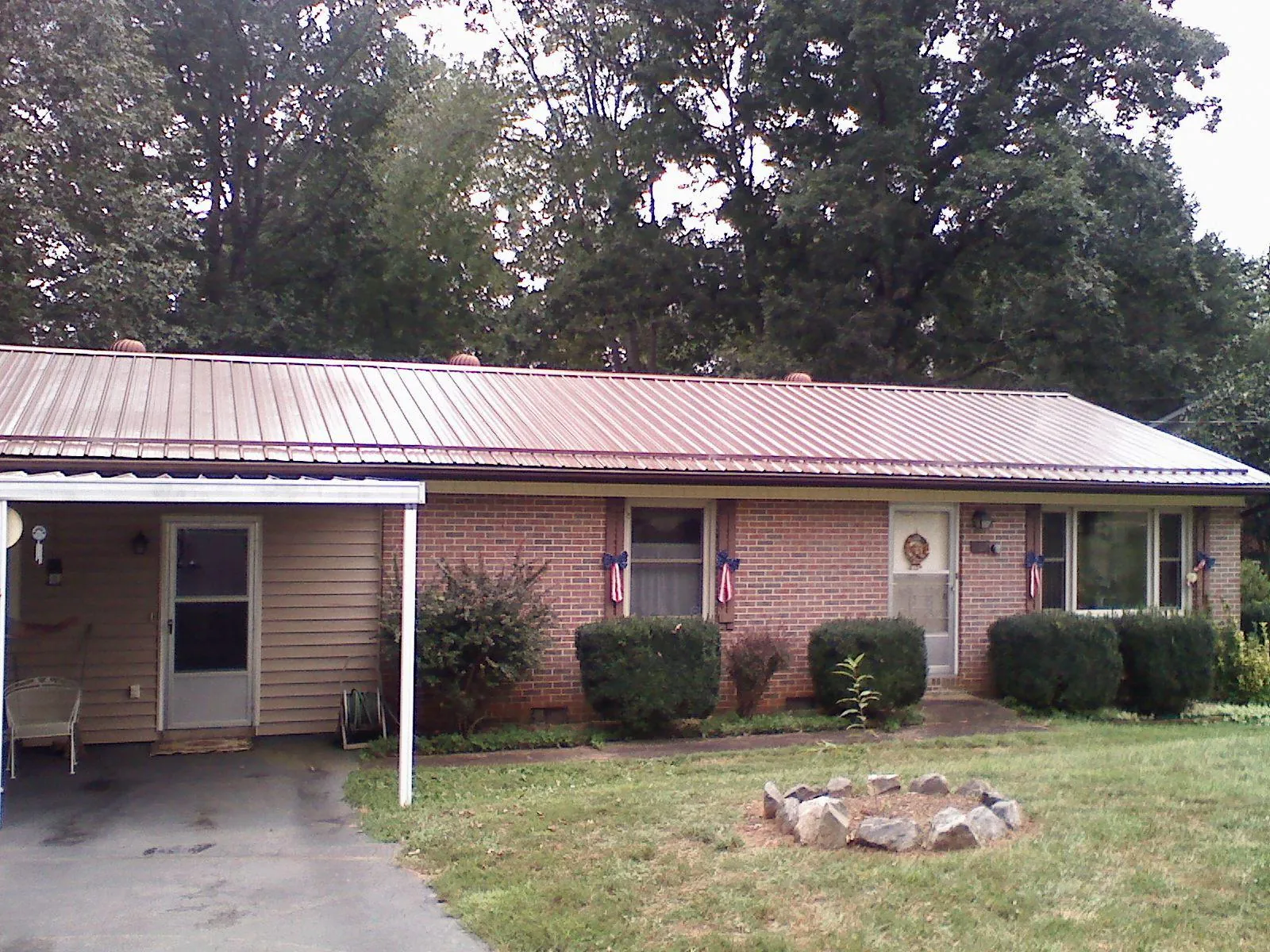 Bronze metal roof and carport on a brick ranch home — Roof Repair work by our crew in Starkville