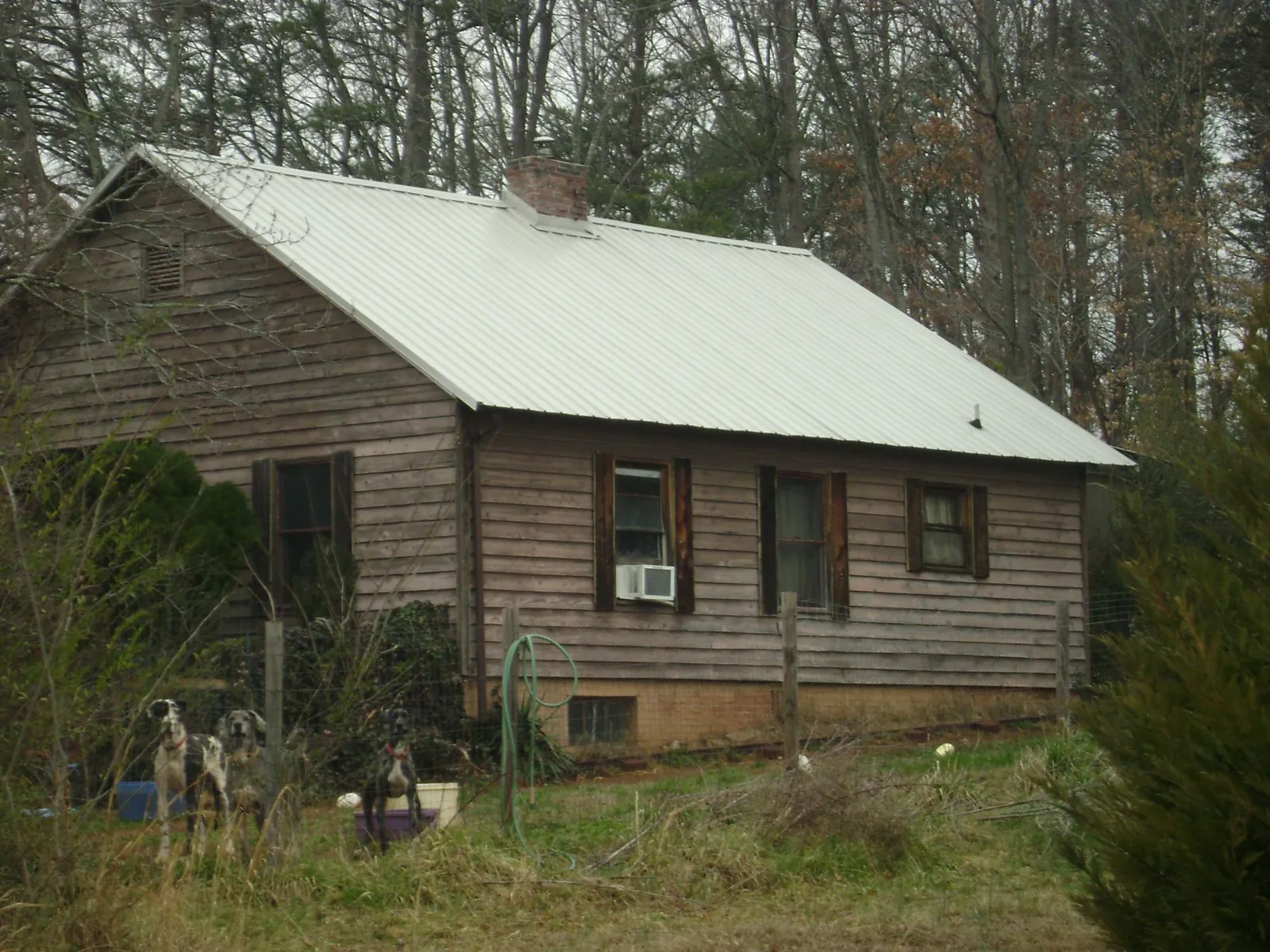 White metal roof on an old wood sided farmhouse, from a Metal Roof Installation job in Starkville